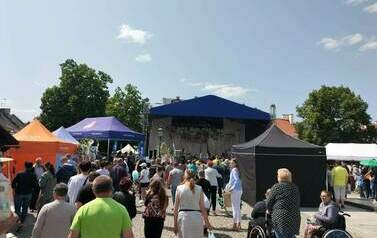 Zdjęcie przedstawia muzyczną scenę, obleganą wkoło przez ludzi