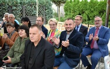 Zdjęcie przedstawia gości siedzących na krzesełkach pod namiotem