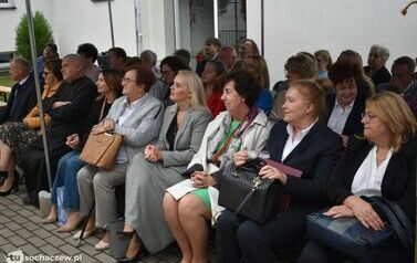 Zdjęcie przedstawia gości siedzących na krzesełkach pod namiotem