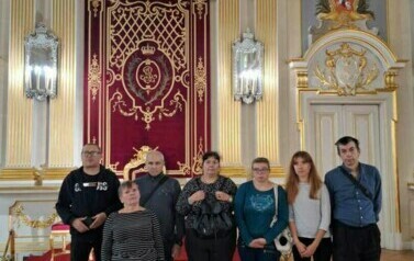 Grupa kobiet i mężczyzn pozująca do zdjęcia w Sali Tronowej Zamku Kr&oacute;lewskiego w Warszawie
