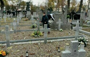 Kobieta stojąca przy grobach Żołnierzy poległych na cmentarzu wojennym