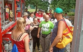 Zdjęcie przedstawia grupę os&oacute;b oglądających wyposażenie wozu strażackiego