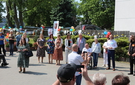 Zdjęcie przedstawia grupę ludzi witających przybyłych gości