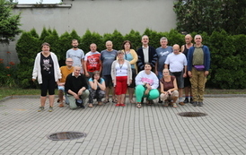 Na zdjęciu grupa kobiet i mężczyzn biorąca udział w "Nocowaniu w ŚDS"