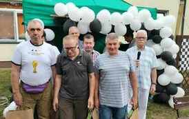 Na zdjęciu grupa sześciu mężczyzn stojących na tle biało-czarnych balon&oacute;w
