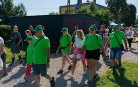 Grupa kobiet i mężczyzn idąca polną drogą
