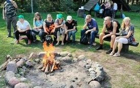 Na zdjęciu grupa os&oacute;b siedzących przy ognisku