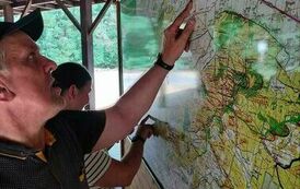 Na zdjęciu mężczyzna oglądający mapę Kampinoskiego Parku Narodowego