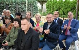 Zdjęcie przedstawia gości siedzących na krzesełkach pod namiotem