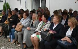 Zdjęcie przedstawia gości siedzących na krzesełkach pod namiotem