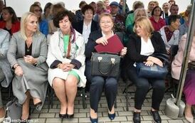 Zdjęcie przedstawia gości siedzących na krzesełkach pod namiotem