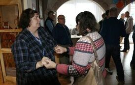 Zdjęcie przedstawia dwie kobiety tańczące w parze podczas zabawy andrzejkowej