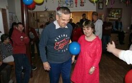 Na zdjęciu kobieta i mężczyzna z balonem pomiędzy nimi, podczas zabawy andrzejkowej