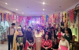 Grupa os&oacute;b pozuje do zdjęcia w przebraniach karnawałowych