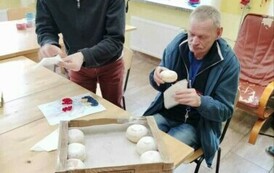 Zdjęcie przedstawia dw&oacute;ch mężczyzn z pączkami