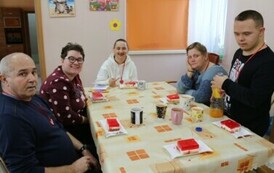 Trzy kobiety i dw&oacute;ch mężczyzn siedzących przy stole podczas spotkania walentynkowego