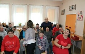 	Grupa os&oacute;b siedzących na krzesłach podczas spotkania walentynkowego