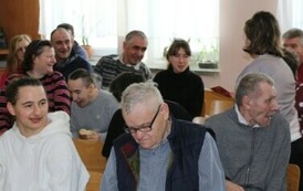 Grupa os&oacute;b siedzących na krzesłach podczas spotkania walentynkowego